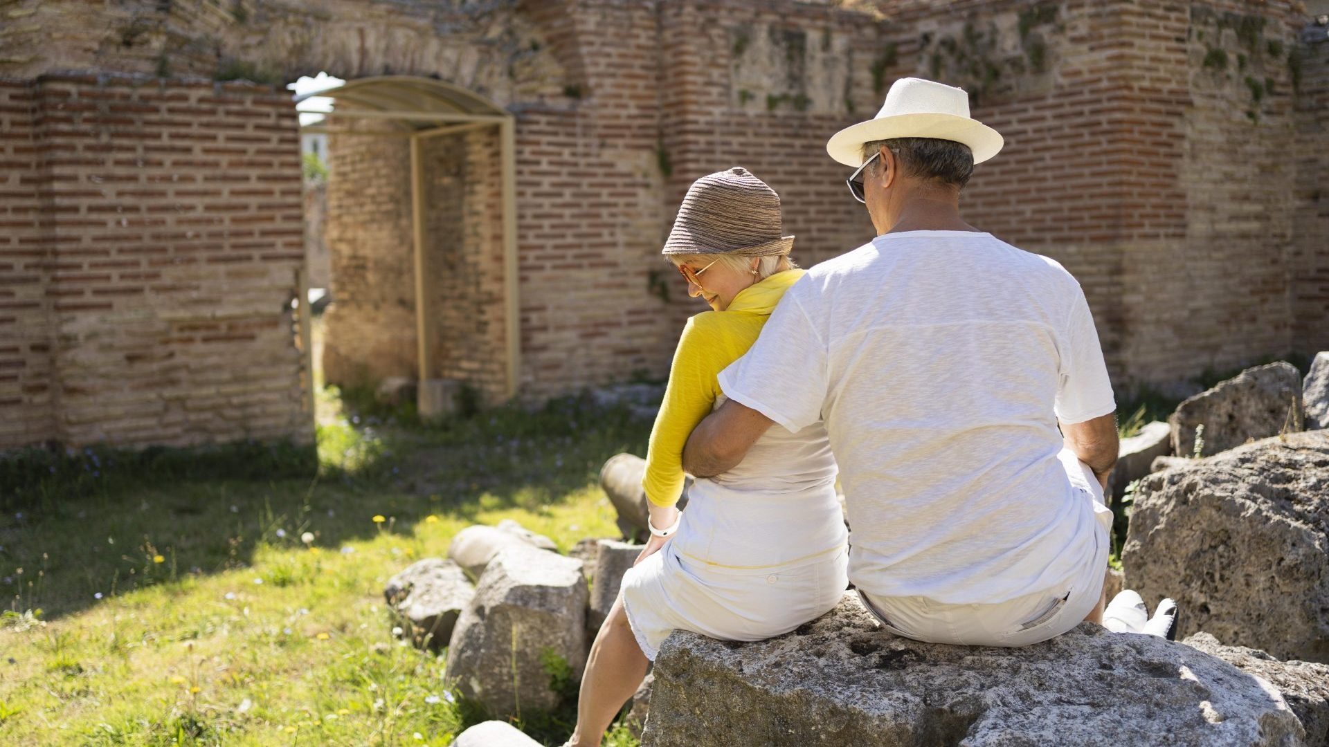back-view-senior-couple-sitting-rock back-view-senior-couple-sitting-rock